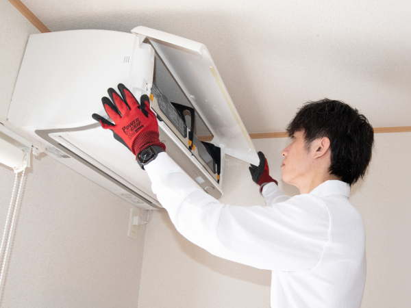 エアコンの中を確認しているスタッフ