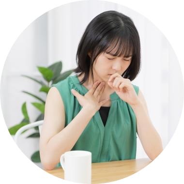 喉を手で押さえている女性