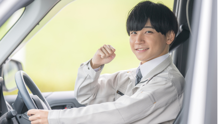 車の運転席でガッツポーズしている男性